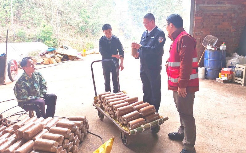 帮扶工作与良冲村食用菌产业基地负责人探讨菌棒生产加工细节。（来源：皇岗边检站）.jpg